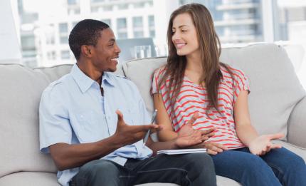 a man and a woman talking on a sofa