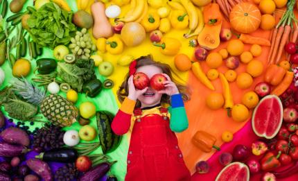 young girl with image of fruit and vegetables behind her