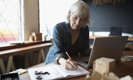 Women writing in a note book at her desk