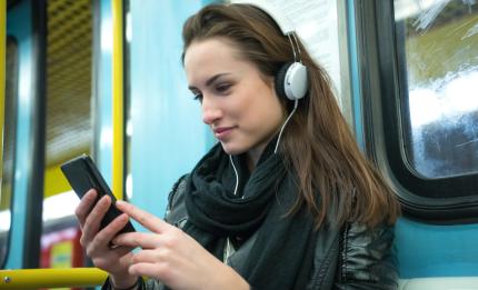 woman with headphones on looking at her phone