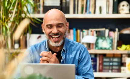 Man laughing in meeting online