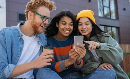 three friends smiling at a mobile phone screen