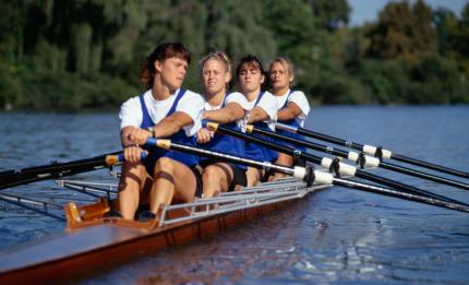 four people rowing in a rowing boat