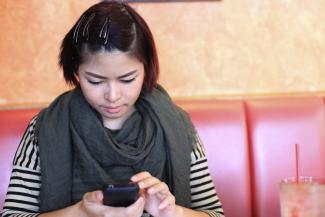 A young woman texts on her phone