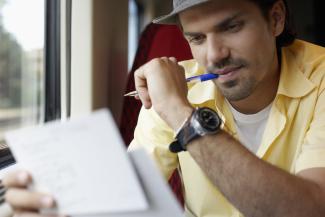 Man sucking on his pen reading 