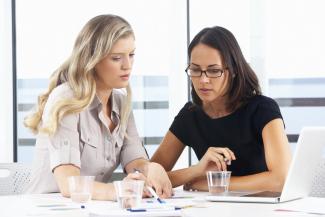 Two workers discussing something in an office