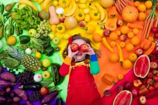 young girl with image of fruit and vegetables behind her