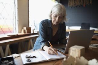 Women writing in a note book at her desk